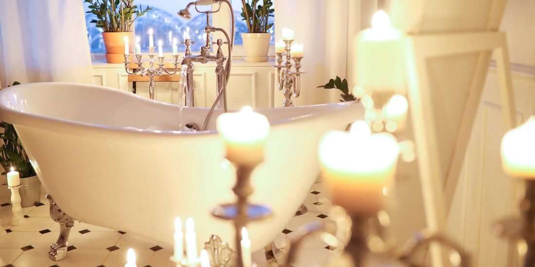 Das Bild zeigt eine freistehende Badewanne mit einem Kerzenmeer im Badezimmer.